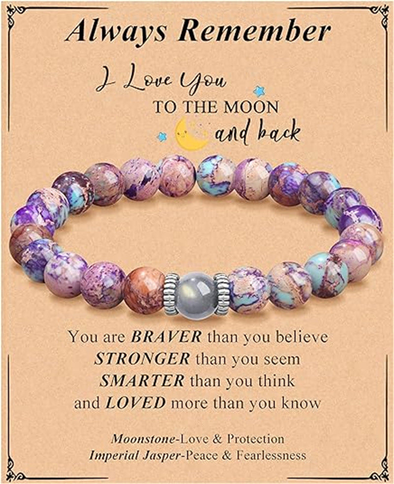 This Natural Purple Emperor Stone Match Moonstone Elastic Beaded Bracelet blends soothing crystal energy with timeless style for everyday wear